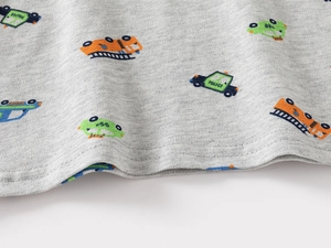 Close-up of grey pique fabric with cartoon vehicle prints and durable double stitching