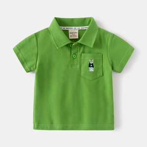 Detail eines grünen Kinder-Poloshirts mit kleiner Bärenstickerei auf der Brusttasche