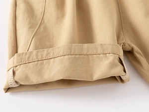 Detail of khaki cotton twill fabric showing professional hem stitching on boys shorts