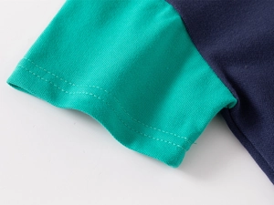 Dettaglio della manica della t-shirt in cotone per bambini con polsini verdi a contrasto