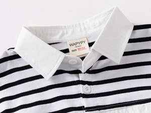Close-up of white collar and button detail on a black and white striped boys polo shirt
