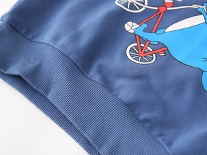 Detail of blue kids hoodie featuring an elephant cycling print and ribbed elastic hemline