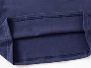 Dettaglio in maglia piqué blu navy con robusto orlo a doppia cucitura su maglia bimbo