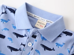 Gros plan du polo bleu pour enfants avec imprimés de baleines et texture en coton