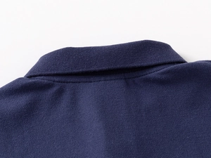 Dettaglio macro del colletto della polo in cotone piqué blu navy e cuciture di qualità