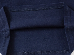 Close-up of navy blue piqué knit fabric hem with durable double-needle stitching