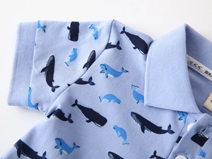 Détail d'un polo à imprimé baleine avec texture en coton piqué et boutons blancs