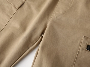 Close-up of khaki twill cotton pants showing precise stitching and side metal zipper