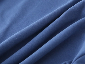 Macro view of blue cotton knitted fabric texture showing soft fibers and fine weave details