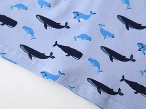 Gros plan sur tissu bleu clair avec imprimé baleine et ourlet à double surpiqûre
