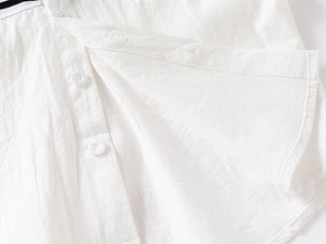 Close-up of white cotton-linen fabric texture with buttons and stitched curved hemline