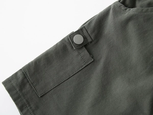 Macro shot of durable olive twill cotton fabric with premium matte metal button and stitching