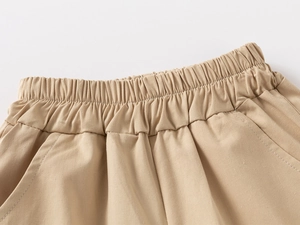 Dettaglio dei pantaloncini in cotone kaki con vita elastica e doppie cuciture sottili
