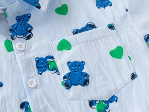 Close-up of boys light blue shirt with bear and heart prints, collar and button detail