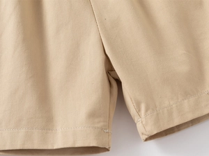 Dettaglio dei pantaloncini di cotone kaki con cuciture rifinite e trama del tessuto