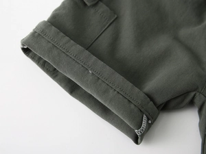 Detailed close-up of olive green cargo shorts featuring double-needle stitching and twill fabric
