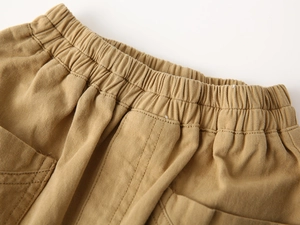 Detail of elastic waistband and reinforced stitching on khaki cotton shorts for boys