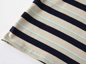 Detailed view of striped cotton fabric with precise double-needle stitching on the hem
