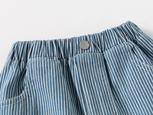 Detail of elastic waist with silver button and vertical stripes on denim shorts