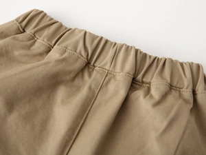 Detail of children's khaki pants featuring an elastic waistband and premium twill fabric
