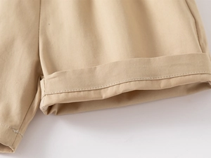 Dettaglio dei pantaloncini in cotone kaki con trama del tessuto e bordo risvoltato