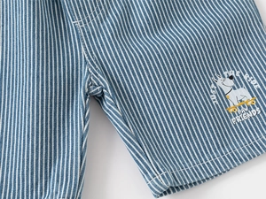 Detail of blue striped cotton shorts featuring a cute dog on a skateboard print