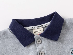 Dettaglio polo grigia per bambini con colletto a costine blu navy e bottoni grigi
