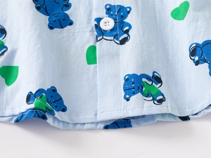 Close-up of light blue cotton shirt featuring cartoon bear prints and white buttons