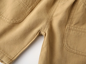 Detailed view of khaki twill cotton fabric and double-stitched pocket on boys' shorts