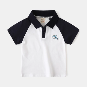Detail of boys' polo shirt with contrast raglan sleeves and embroidered blue shark logo
