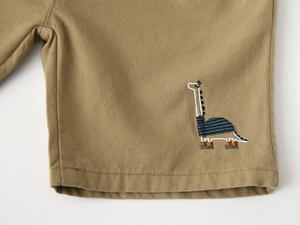 Détail d'un short en coton kaki pour enfant avec broderie de dinosaure de haute qualité