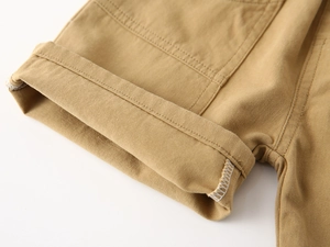 Close-up of khaki cotton shorts showing neatly cuffed hems and durable inner stitching