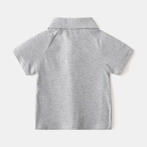 Vue détaillée du polo gris pour enfant montrant les manches raglan et la couture
