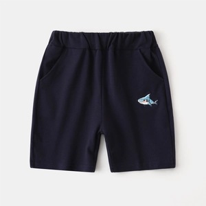 Detail of navy blue boys knit shorts featuring shark embroidery and elastic waistband