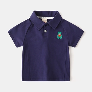 Détail d'un polo bleu marine pour enfant avec broderie ours vert et col classique polo