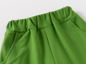 Detail of green knit shorts featuring elastic waistband and reinforced side pocket stitching