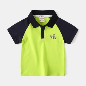 Detail of neon green polo shirt with shark embroidery and navy contrast sleeve stitching