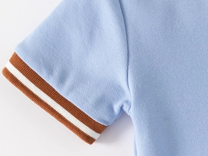 Macro shot of light blue piqué fabric polo sleeve with brown ribbed trim and white line