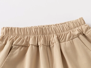 Detail of boys cotton shorts showing elastic waistband and side pocket stitching