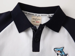 Detail of shark embroidery and contrast collar on the boys' cotton polo shirt
