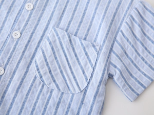 Close-up of light blue striped short-sleeve shirt showing chest pocket and white buttons