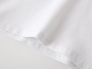 Detailed close-up of double-needle stitching on premium white cotton polo shirt hem
