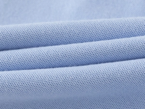 Macro shot of light blue cotton pique fabric showing honeycomb texture for polo shirts