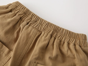 Detail of elastic waistband and stitching on boys' cotton twill casual shorts