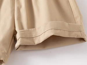 Detailed macro view of khaki cotton twill shorts showing high-quality hem stitching