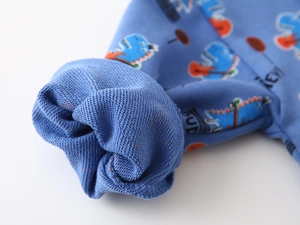 Detail of blue dinosaur sweatshirt cuff showing soft french terry cotton texture