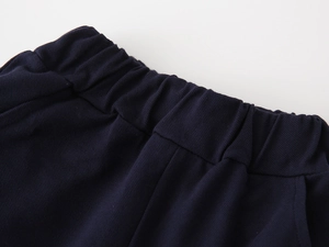 Detail of navy blue elastic waistband with reinforced stitching on boys' summer shorts