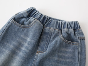 Detailed close-up of elastic waist and contrast stitching on boys' light blue denim jeans