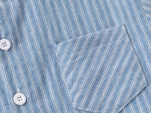 Detailed view of light blue striped cotton shirt texture and pocket stitching craftsmanship