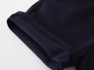 Detailed view of neat stitching and elastic cuff on boys navy blue summer polo shirt